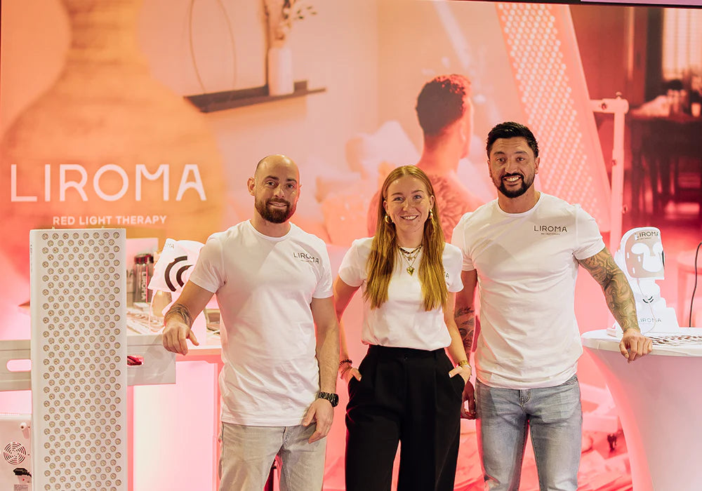 The Liroma team at the booth with a red-light panel